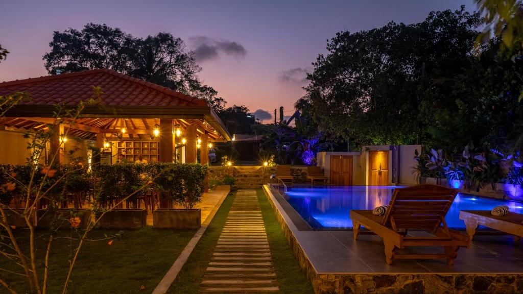 a house with a swimming pool at night at Villa Bentota B24 in Bentota