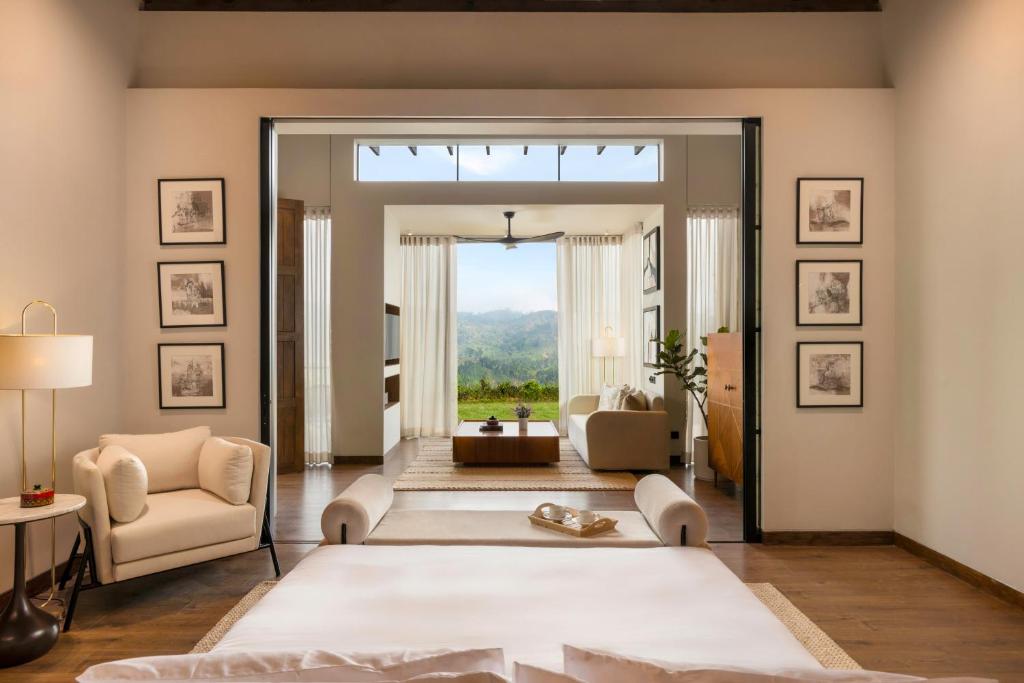 a living room with a large window and a couch at Uga Ghiri - Ella - All Inclusive in Ella