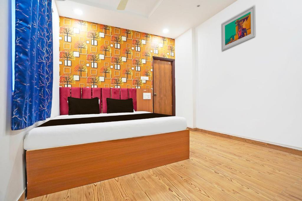 a bedroom with a bed and a painting on the wall at Super Hotel O Sunshine Villa in Nagpur