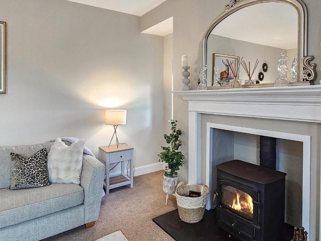 a living room with a fireplace and a couch at Darris Farmhouse in Lochend