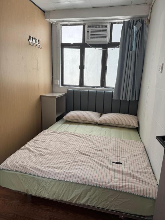 a small room with a bed and a window at 旅居2wubin in Hong Kong