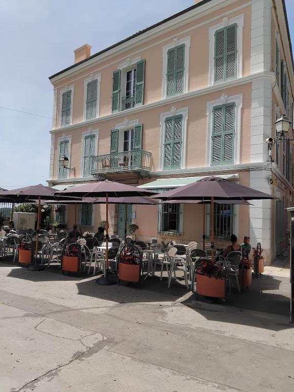 a building with tables and umbrellas in front of it at Chez Jo Fayence in Fayence