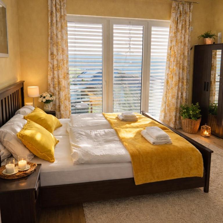 a bedroom with a large bed with yellow sheets and a window at Apartment im schönen Taunus in Dickschied