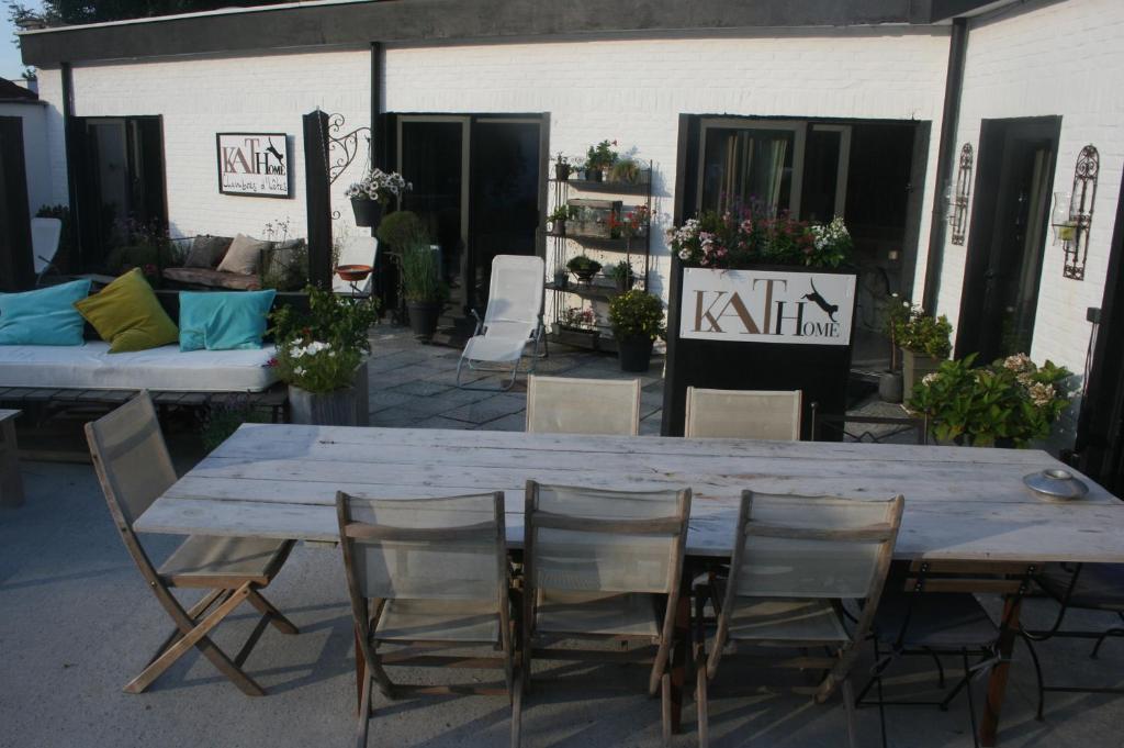 een grote houten tafel met stoelen en een bank bij Guesthouse Kathome in Bondues