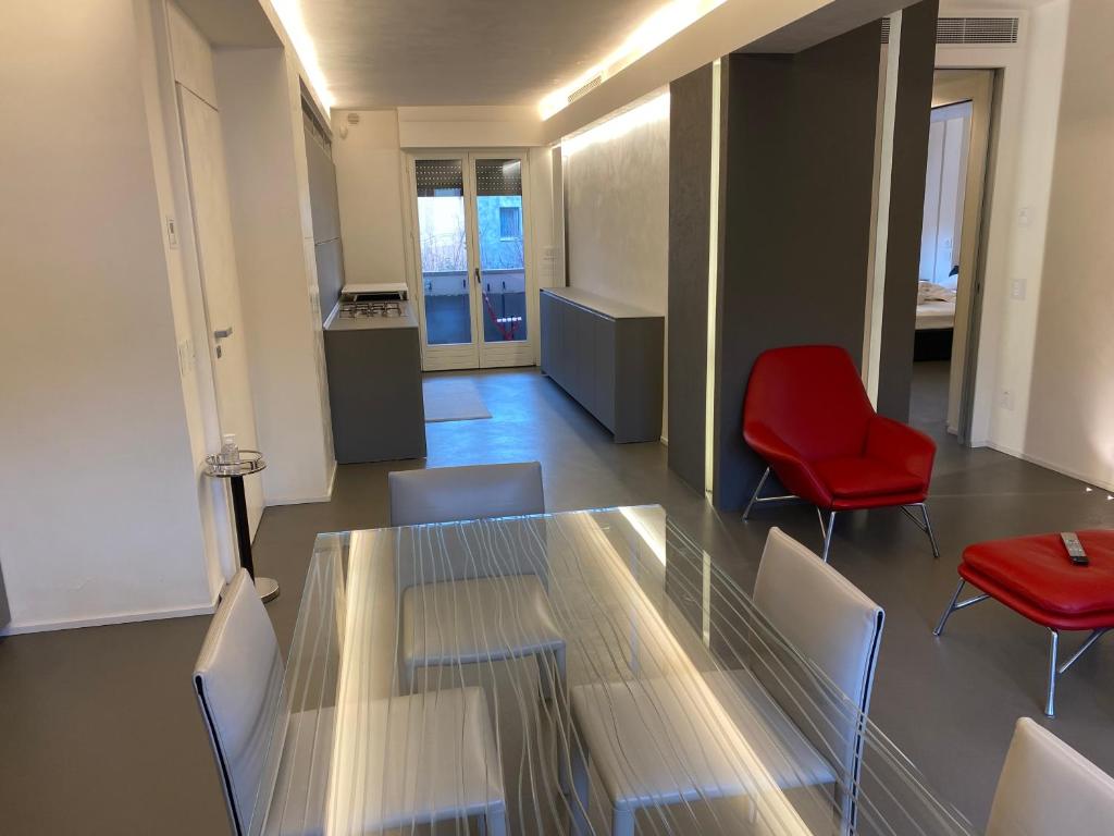 a conference room with a glass table and red chairs at Cortirola luxury apartment in Pesaro