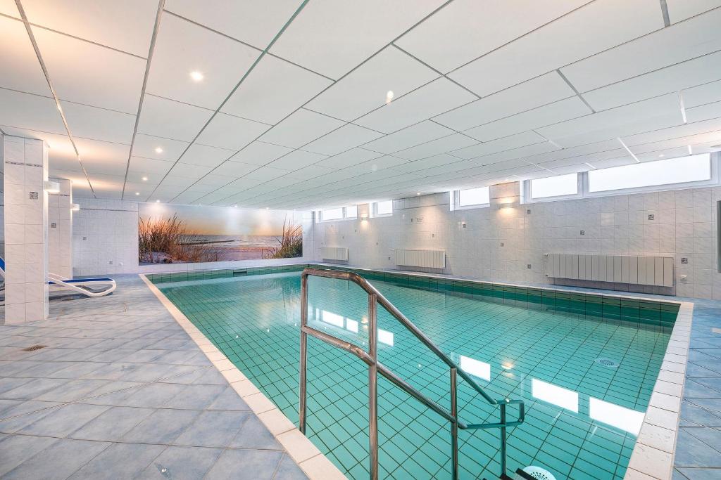 a large swimming pool in a building at Wellness Ferienwohnung Strandperle in Cuxhaven