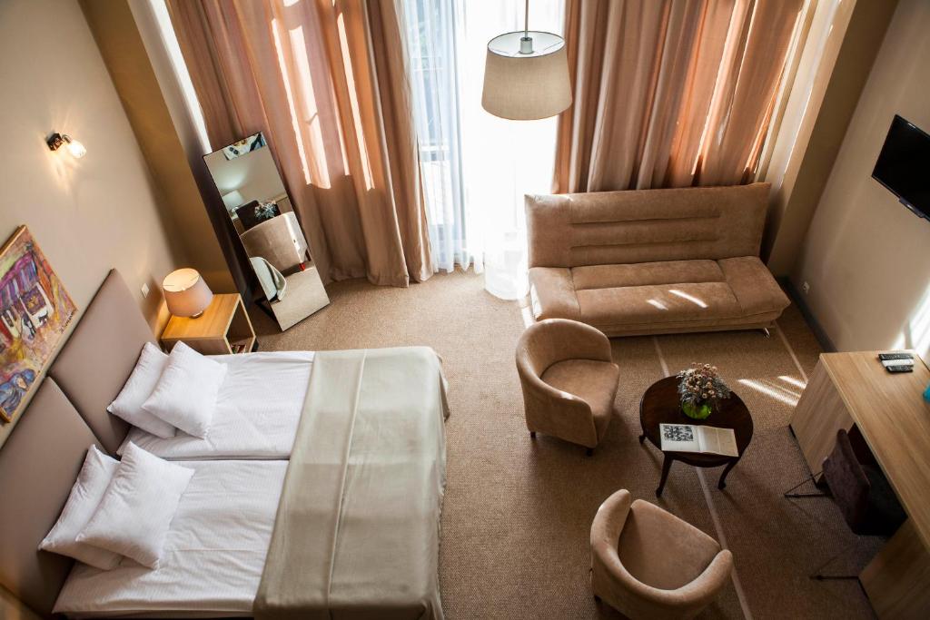 a hotel room with a bed and a chair at Boutique Hotel Amra in Sukhum