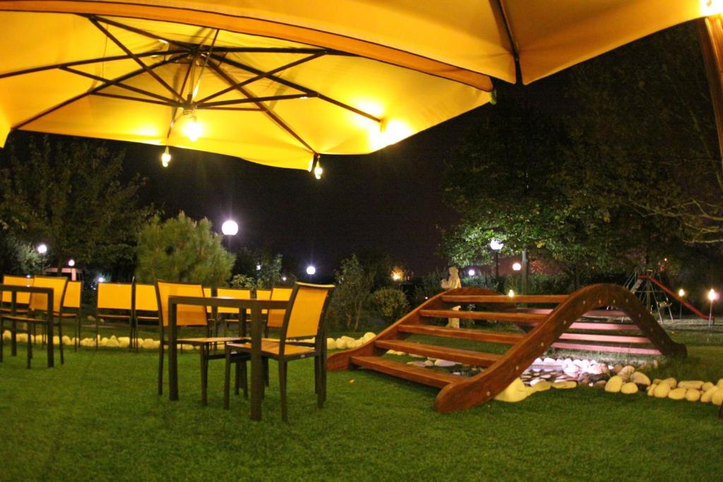 eine Terrasse mit einem Sonnenschirm, einem Tisch und Stühlen in der Unterkunft Hotel Il Maglio in Imola