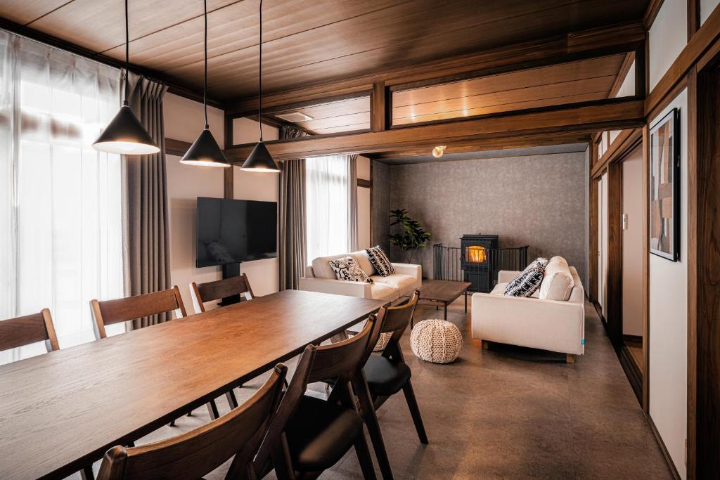 a living room with a large wooden table and chairs at Villa Mimosa Myoko in Myoko