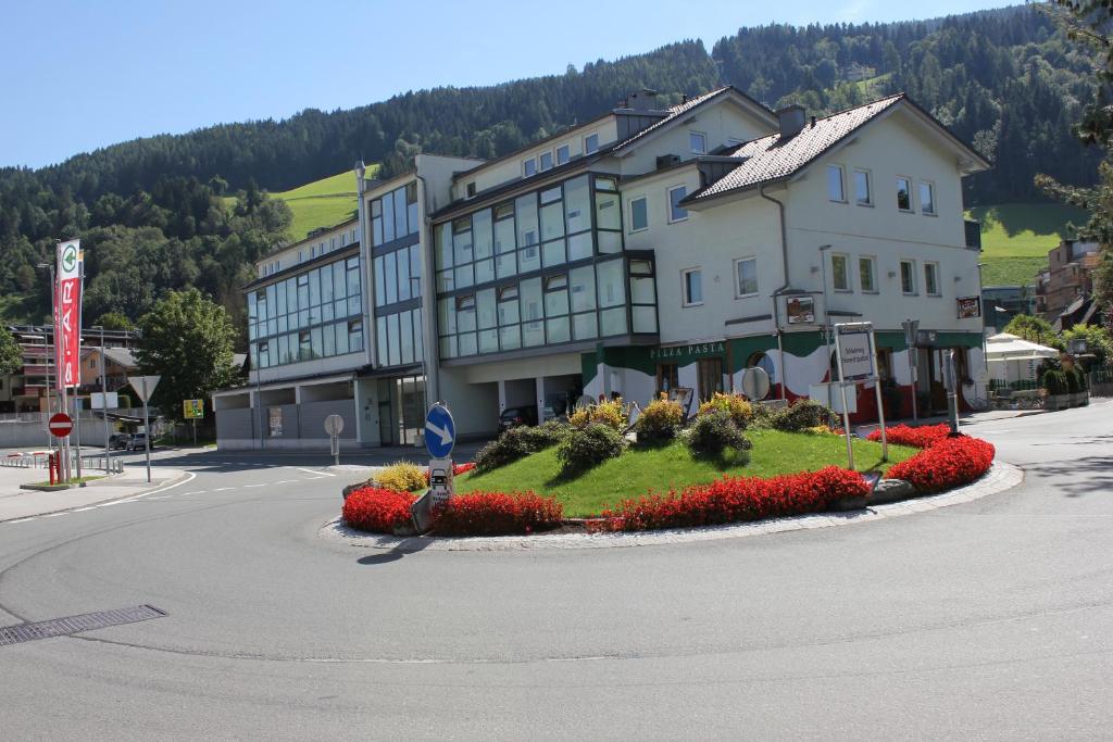 ein großes Gebäude mit einem Blumenbett in der Mitte einer Straße in der Unterkunft Jasmin in Schladming