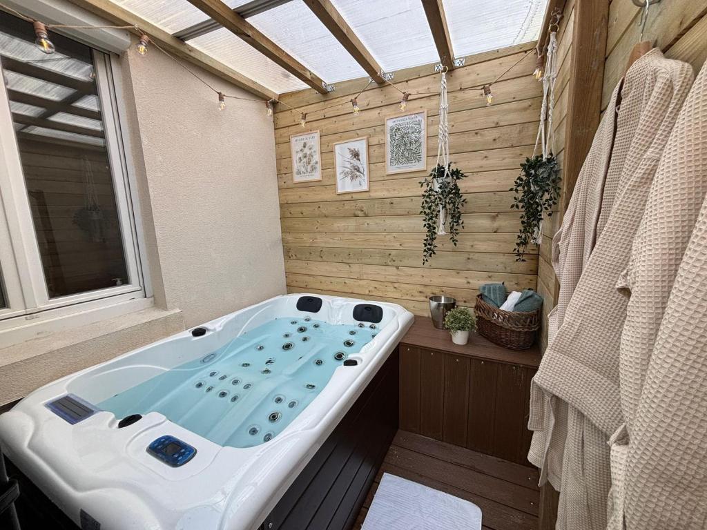 a jacuzzi tub in a bathroom with a window at Location Maison Larmor plage in Larmor-Plage