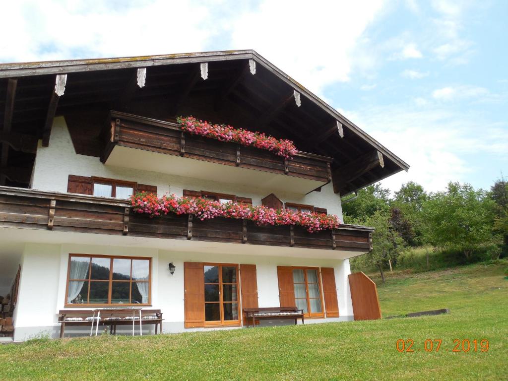 a building with a balcony with flowers on it at Schmidhauser Hof in Unterwössen