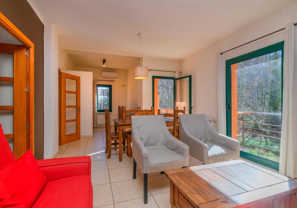 a living room with a red couch and a table at Cal Metge de Gualba in gualba de Dalt
