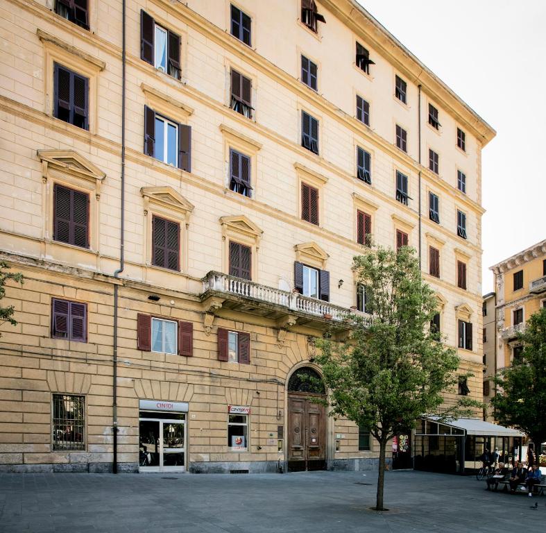 um grande edifício de tijolos com uma árvore em frente em Affittacamere Margherita em La Spezia