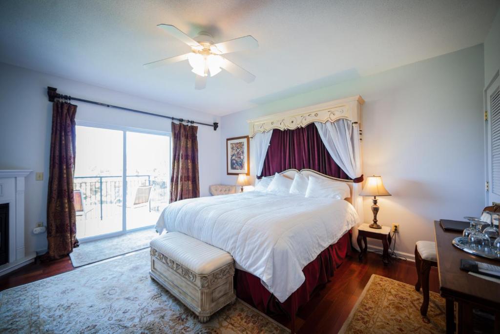 a bedroom with a bed and a large window at La Tourelle Hotel & Spa in Ithaca