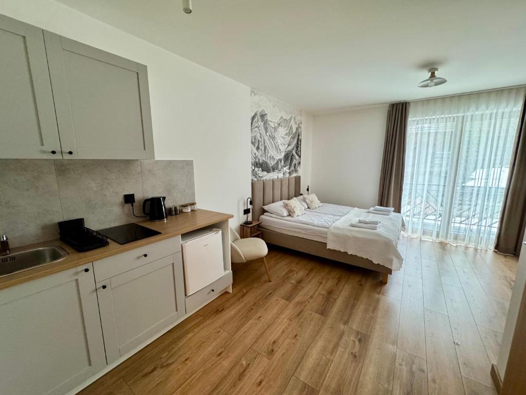 a kitchen with a bed in the middle of a room at Tatrini in Białka Tatrzańska