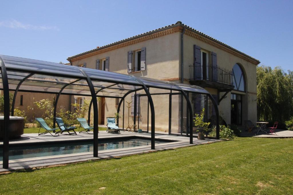 uma casa com piscina no quintal em La Grande Oasis et l'Oasis - Gîtes et Spa em Grazac