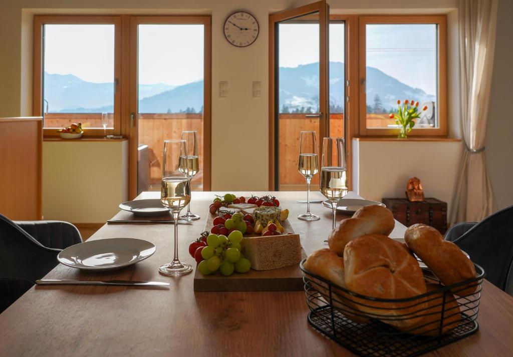 a table with a bunch of bread and wine glasses at Ferienwohnung Vögel in Langenegg