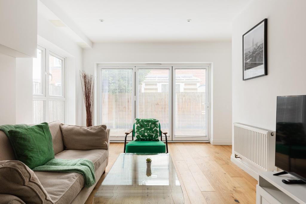 a living room with a couch and a tv at New! Bright 2BR Flat with Patio in Elmers End