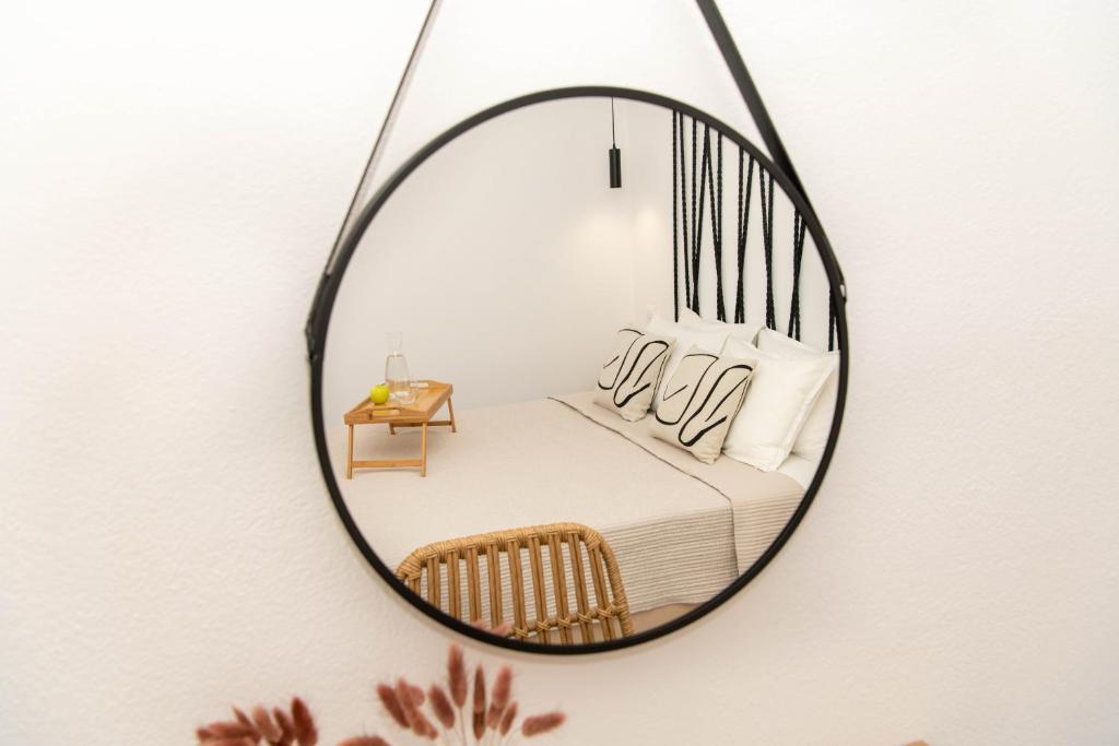 a mirror hanging on a wall with a bed at Casa De Lago in Agios Nikolaos