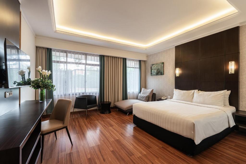 a hotel room with a bed and a desk at Bentani Hotel & Residences Cirebon in Cirebon