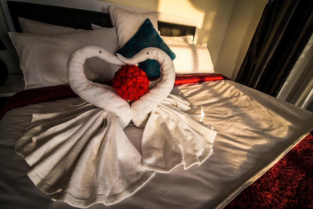 a bed with two heart shaped towels on it at Al Mawaleh Furnished Flats & Rooms in Mawāliḩ