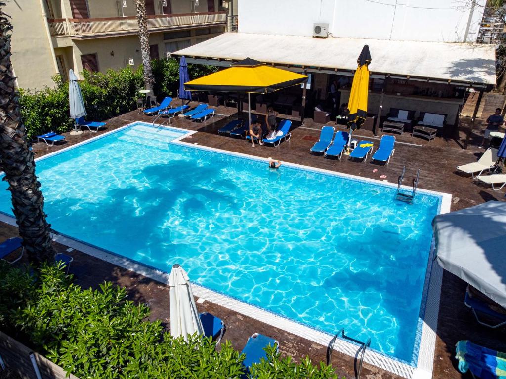 an overhead view of a pool with chairs and umbrellas at Hotel Ena - Elegant Mountain View Stay with Pool in Loutra Ipatis