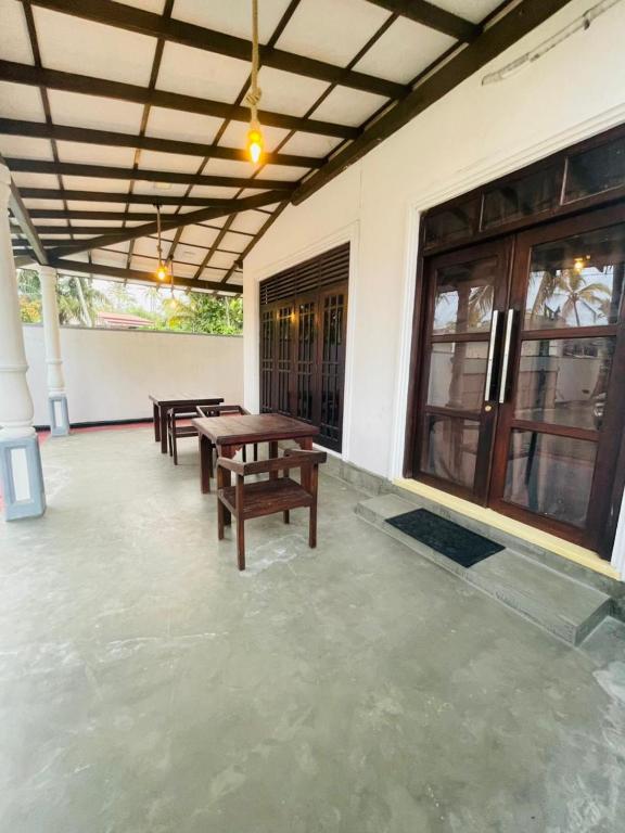 a patio with benches and tables on a building at Janaka Villa - Ahangama in Ahangama