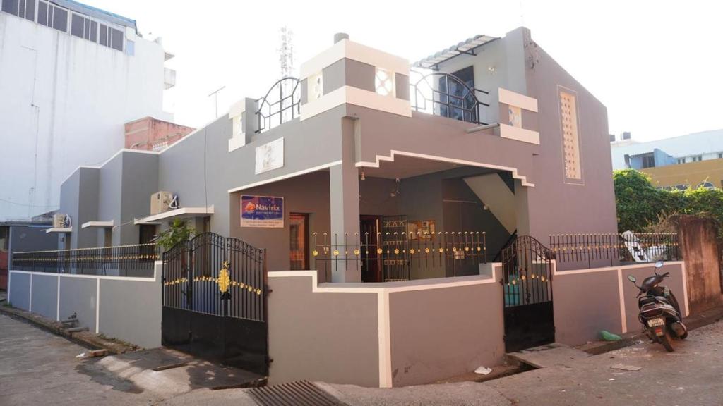 a building with a motorcycle parked in front of it at Grey Pearl Homestay in Pondicherry