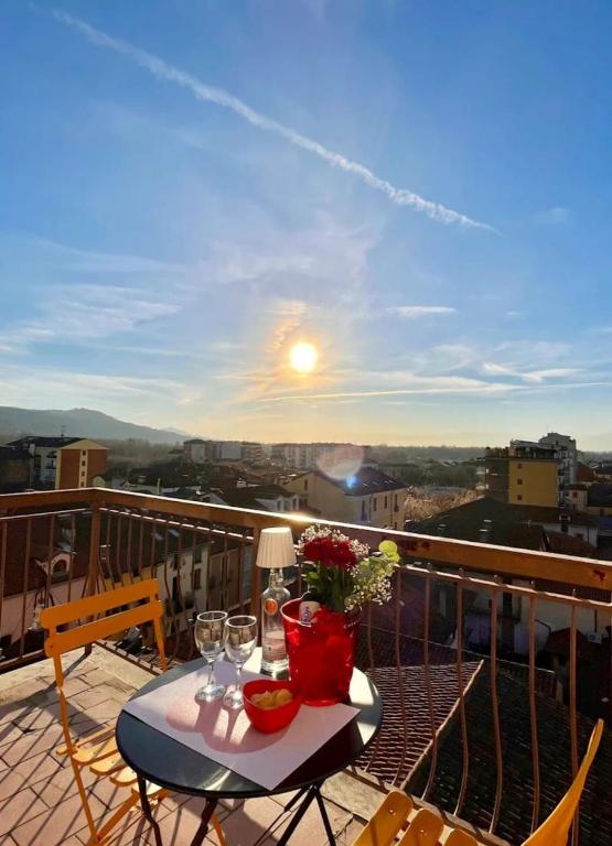 a table with wine glasses and flowers on a balcony at Casa Carletti in Chivasso