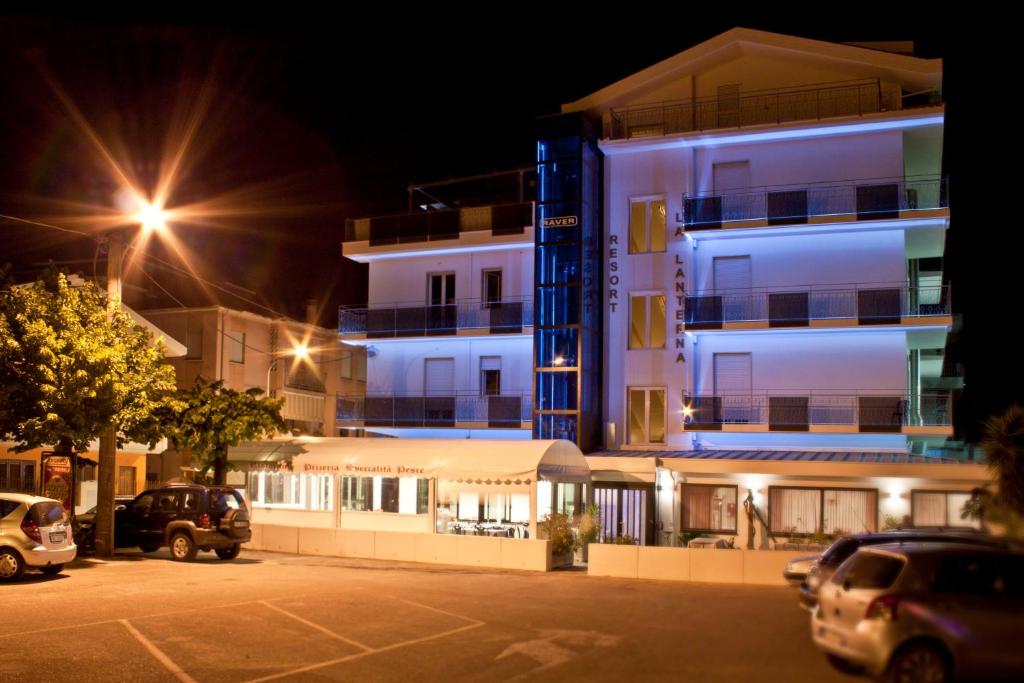 a parking lot in front of a building at night at La Lanterna in Silvi Marina