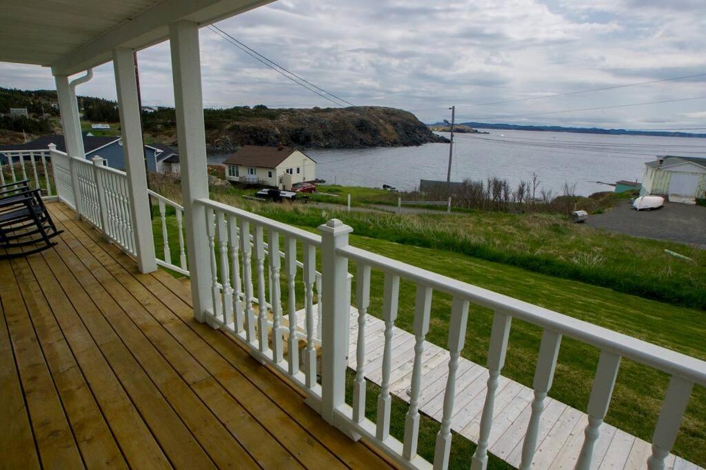 eine Veranda eines Hauses mit Blick auf das Wasser in der Unterkunft Skipper Tom's in Twillingate