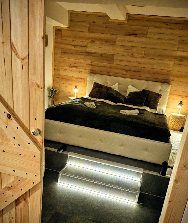 a bedroom with a large bed with a wooden wall at INsight - workcation oldtown in Ingolstadt
