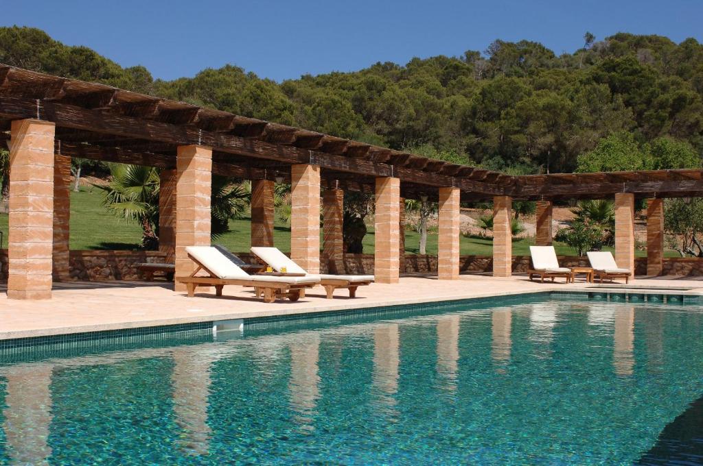uma piscina com espreguiçadeiras e um pavilhão em Hotel Rural Son Terrassa em Caʼs Concos