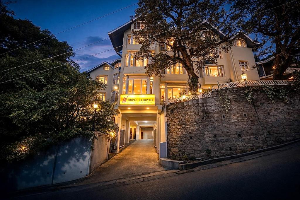 a large white building with lights on it at night at Tripli Hotels Le Royale, Shimla in Shimla