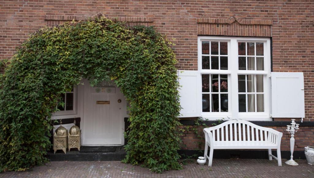 a white bench sitting in front of a building at Apartment Naarden-Vesting in Naarden