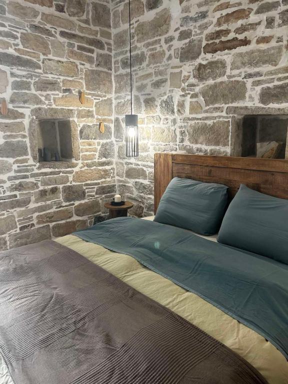a bedroom with a stone wall with a bed at Petrino Minimal in Dhéndra