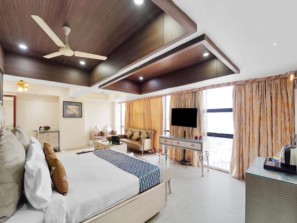 a bedroom with a bed and a living room with a tv at Palette Orient Hotel & Convention Centre by CheckIn, Nagpur in Nagpur