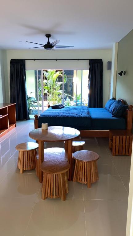 a living room with a bed and two tables and benches at Spy Home apartment in Khao Lak