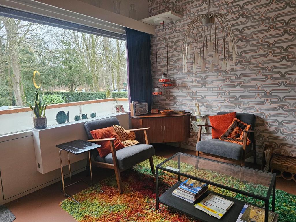 a living room with two chairs and a window at appartement Kemperberg in Arnhem