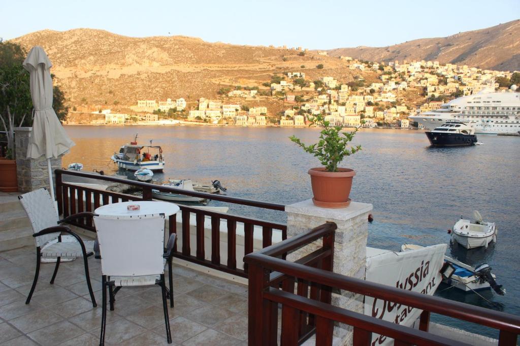 a balcony with a view of a body of water at Odyssia in Symi