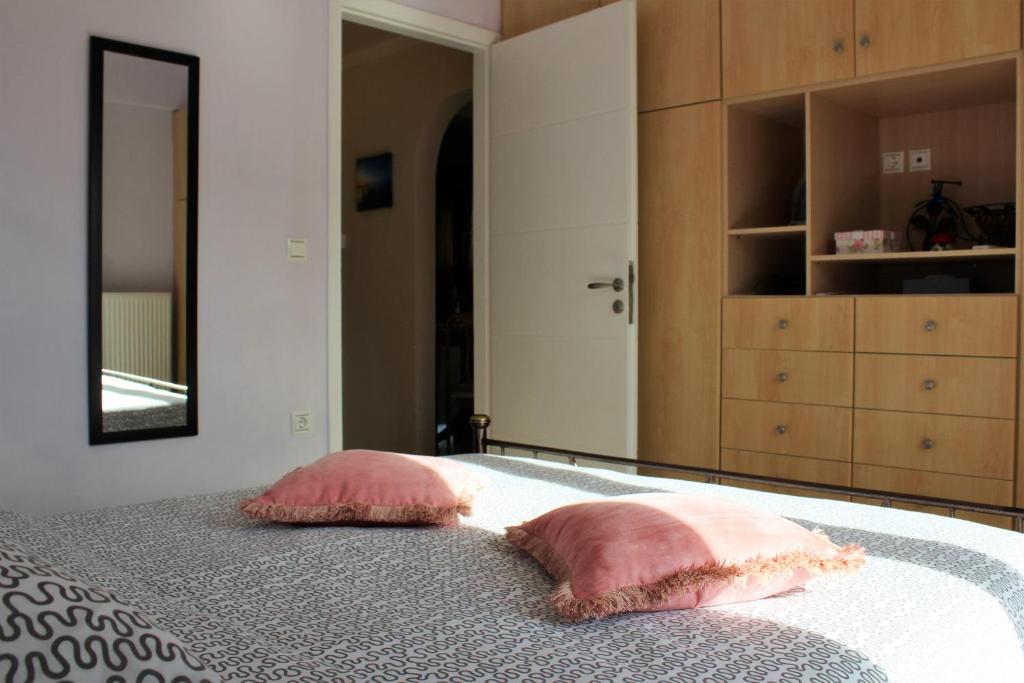 two pink pillows on a bed in a bedroom at Helen's Sounio Apartments in Sounio
