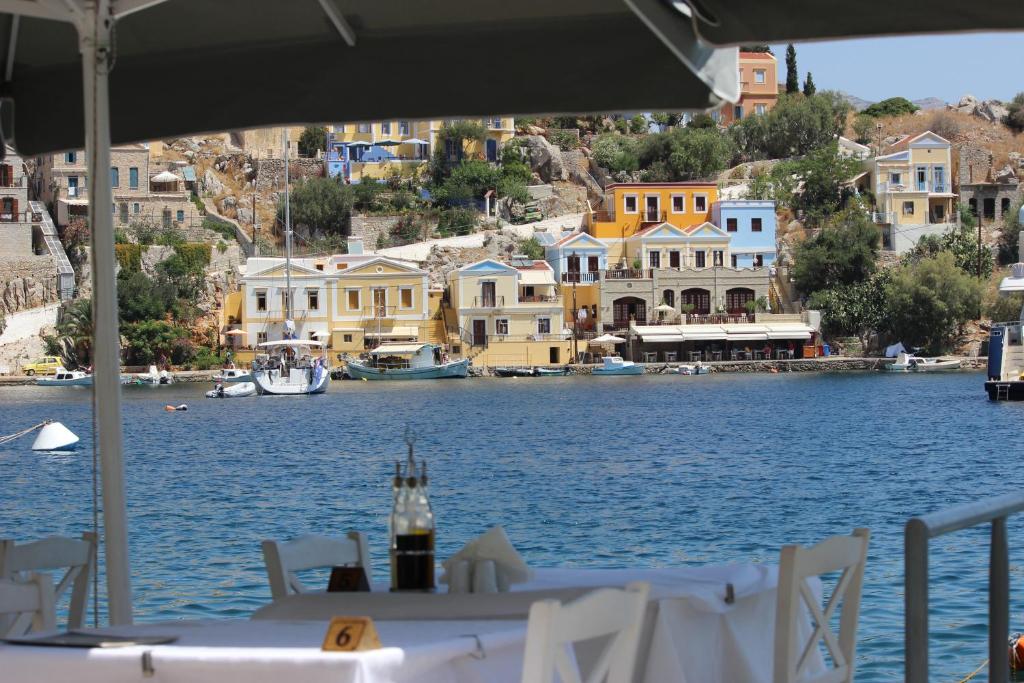 a table with a bottle of wine on top of a body of water at Odyssia in Symi