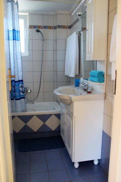 a bathroom with a sink and a toilet and a shower at Helen's Sounio Apartments in Sounio