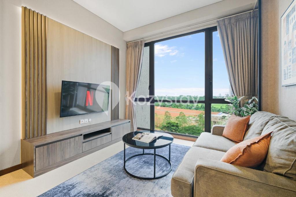 a living room with a couch and a tv at Velir by Kozystay - BSD in Cilenggang