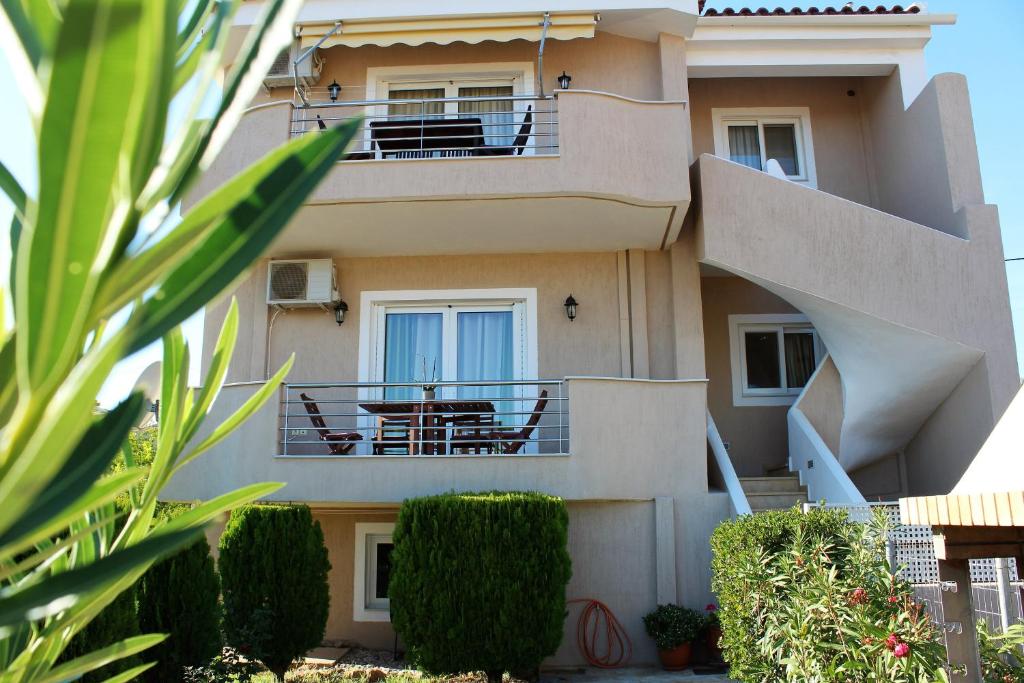 a building with a balcony with a table on it at Helen's Sounio Apartments in Sounio