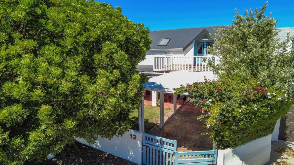 a house with a white fence and two trees at Griki in Paternoster
