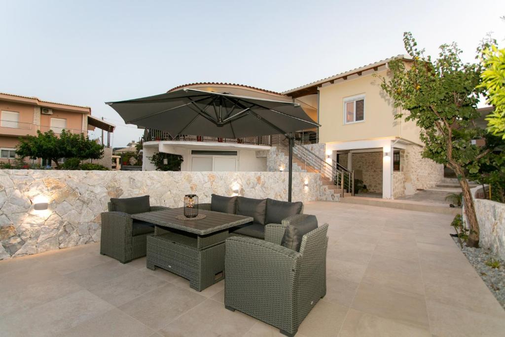 a patio with a table and chairs and an umbrella at Akrolithia Guest House in Valanidorachi