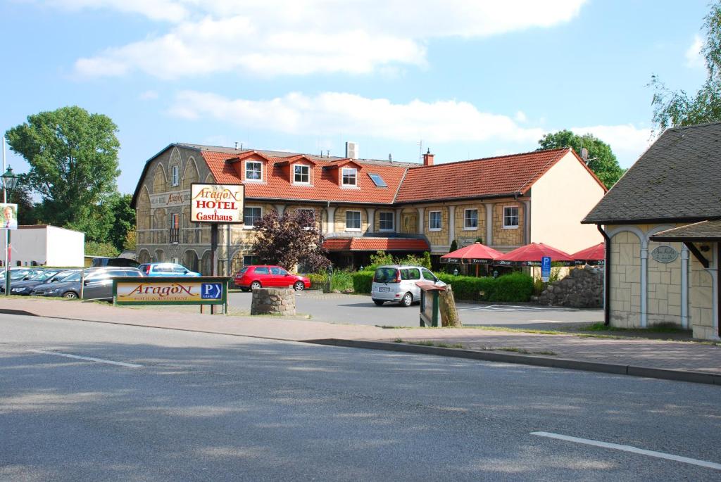 eine Straße mit vor einem Gebäude geparkten Autos in der Unterkunft Hotel Aragon in Ahrensfelde