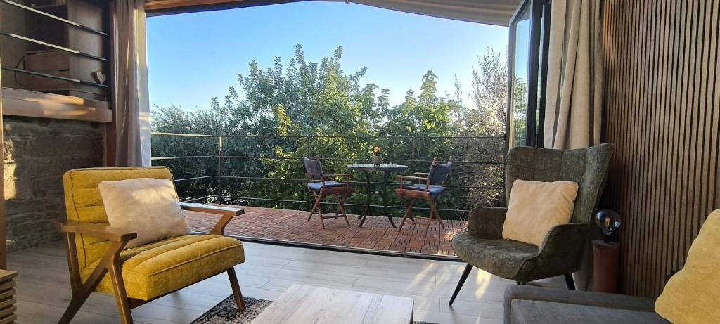a room with two chairs and a balcony with a table at The Zephyr House -2- in Pyrgos
